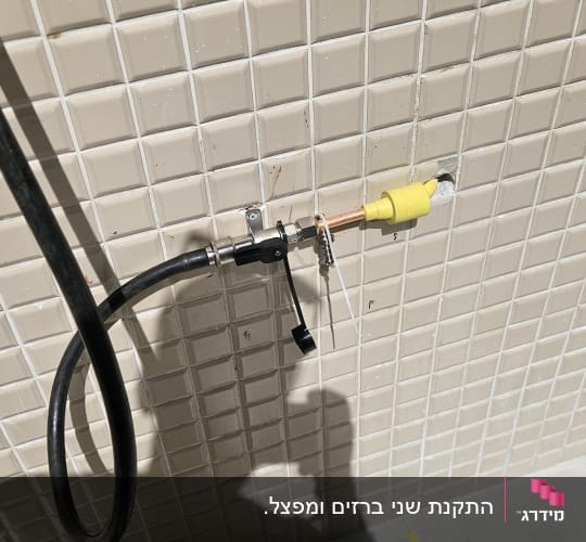 צינור גז מחובר לשסתום על קיר אריחים